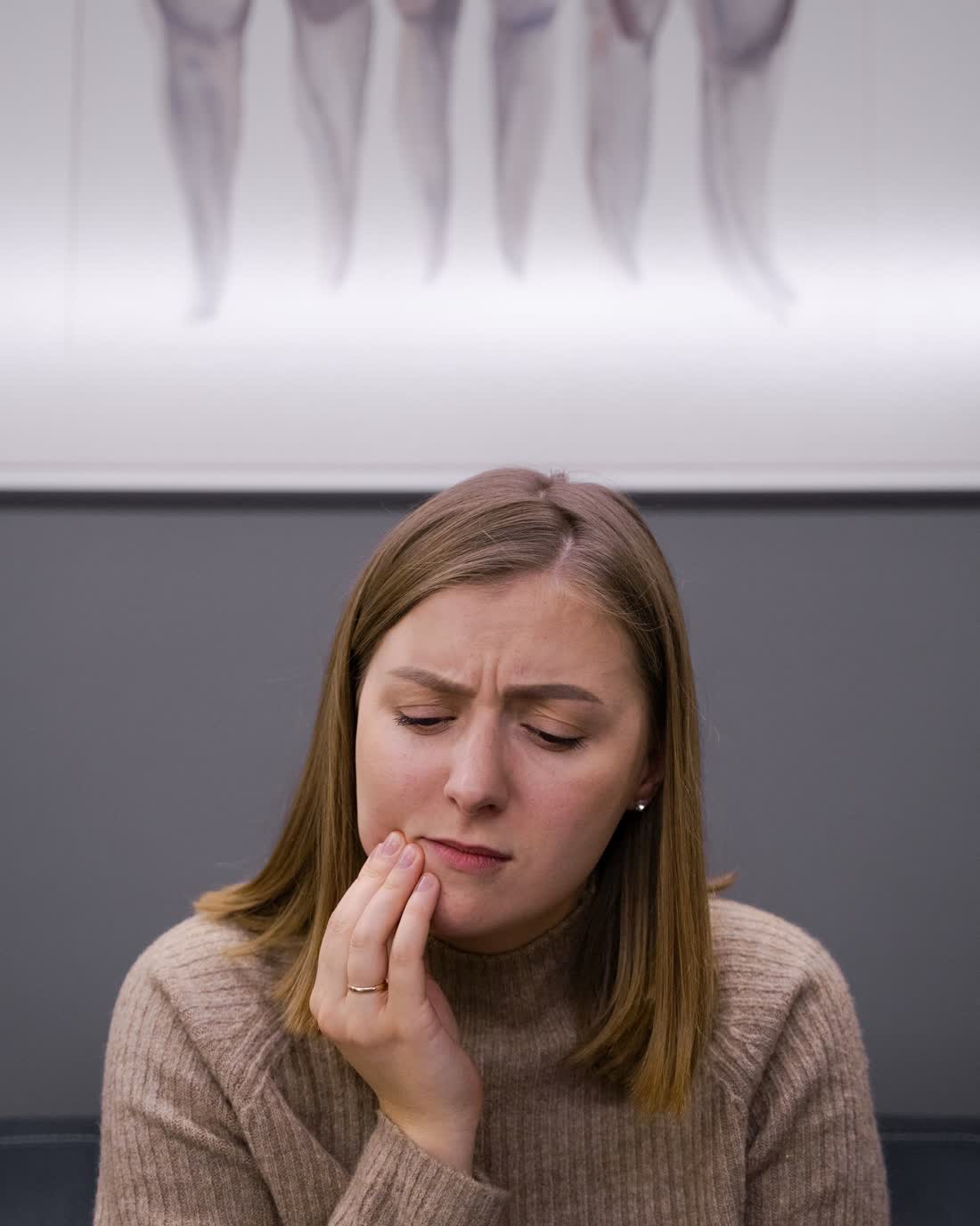 A woman holding her cheek in pain from a severe toothache